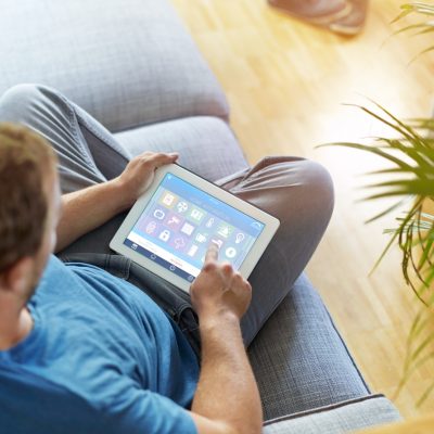 A man sitting on the sofa using a tablet